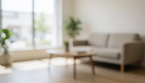Arrière-plan d'un salon moderne avec canapé beige, table en bois et plantes, éclairage naturel doux, idéal pour ajouter du texte publicitaire.