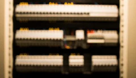 Arrière-plan flou professionnel d'un panneau de contrôle avec interrupteurs et bornes pour textes techniques.