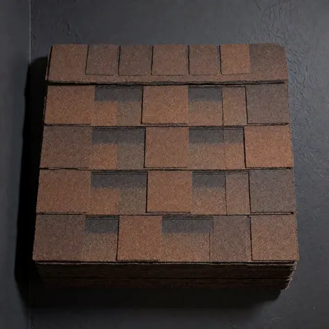 Des tuiles d'asphalte marron empilées en grille sur fond gris anthracite, révélant leur texture granulée et leur motif de recouvrement.