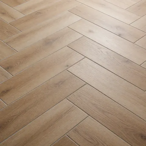 Sol en céramique imitant le bois avec un motif en chevrons, finition mate et texture réaliste. Éclairage neutre mettant en valeur la durabilité et les lignes épurées du revêtement de sol.