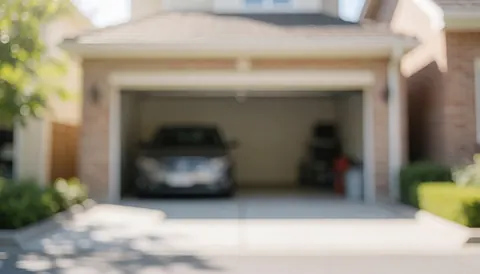 Fond de garage domestique avec voiture garée, murs en briques et végétation, éclairage naturel doux et flou idéal pour textes.