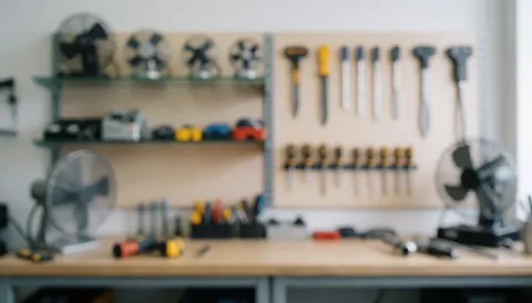 Arrière-plan flou d'un atelier de réparation de ventilateurs avec étagères, outils suspendus et ventilateurs sur la table, ambiance professionnelle et propre