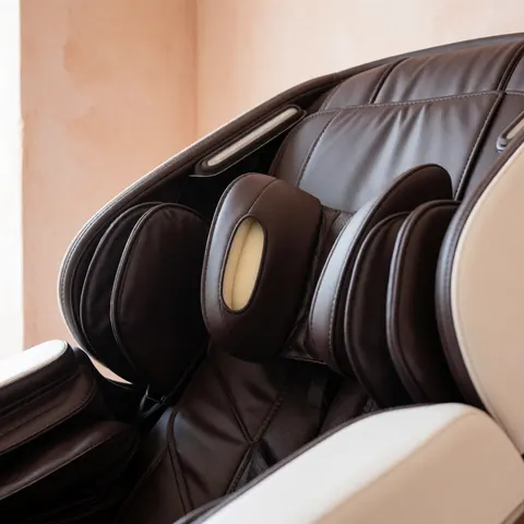 Lit de massage équipé d'un coussin à mémoire de forme, dans une pièce aux murs en enduit terracotta baignée de lumière naturelle.