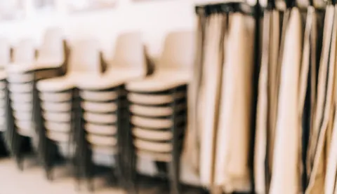 Arrière-plan de showroom avec chaises empilées et échantillons de tissu, idéal pour du texte, tons chauds et ambiance professionnelle.