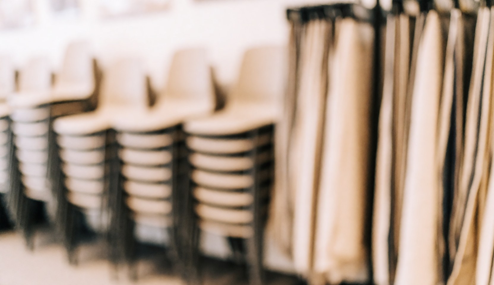 Arrière-plan de showroom avec chaises empilées et échantillons de tissu, idéal pour du texte, tons chauds et ambiance professionnelle.