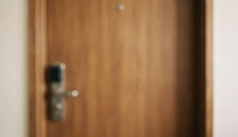 Porte en bois avec une serrure moderne sur un fond flou, idéal pour des textes liés aux services de sécurité.