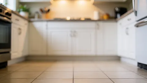Arrière-plan de cuisine moderne avec placards blancs, sol en carreaux et éclairage chaleureux, idéal pour textes ou logos commerciaux.