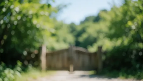 Fond flou montrant une entrée de parc avec une porte en bois et du feuillage vert, idéal pour l'écotourisme et l'éducation environnementale.