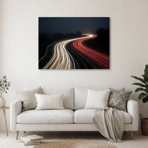 Photographie artistique en longue exposition montrant des traînées lumineuses rouges et blanches sur une route courbe sous un ciel sombre, présentée comme décoration murale.