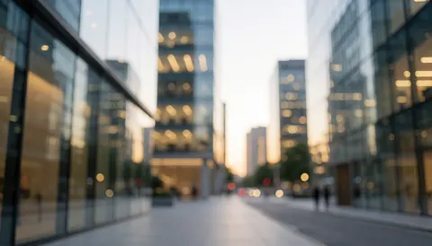 Fond urbain avec des immeubles modernes en verre, des lumières chaudes en bokeh, sans personnes, idéal pour des textes commerciaux