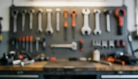 Arrière-plan d'un atelier de mécanique moto avec outils accrochés au mur, tables de travail et éclairage doux pour insérer du texte.