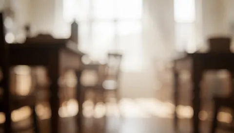 Fond doux et flou de meubles en bois dans un atelier avec une lumière chaude, idéal pour ajouter du texte sur des services de réparation.