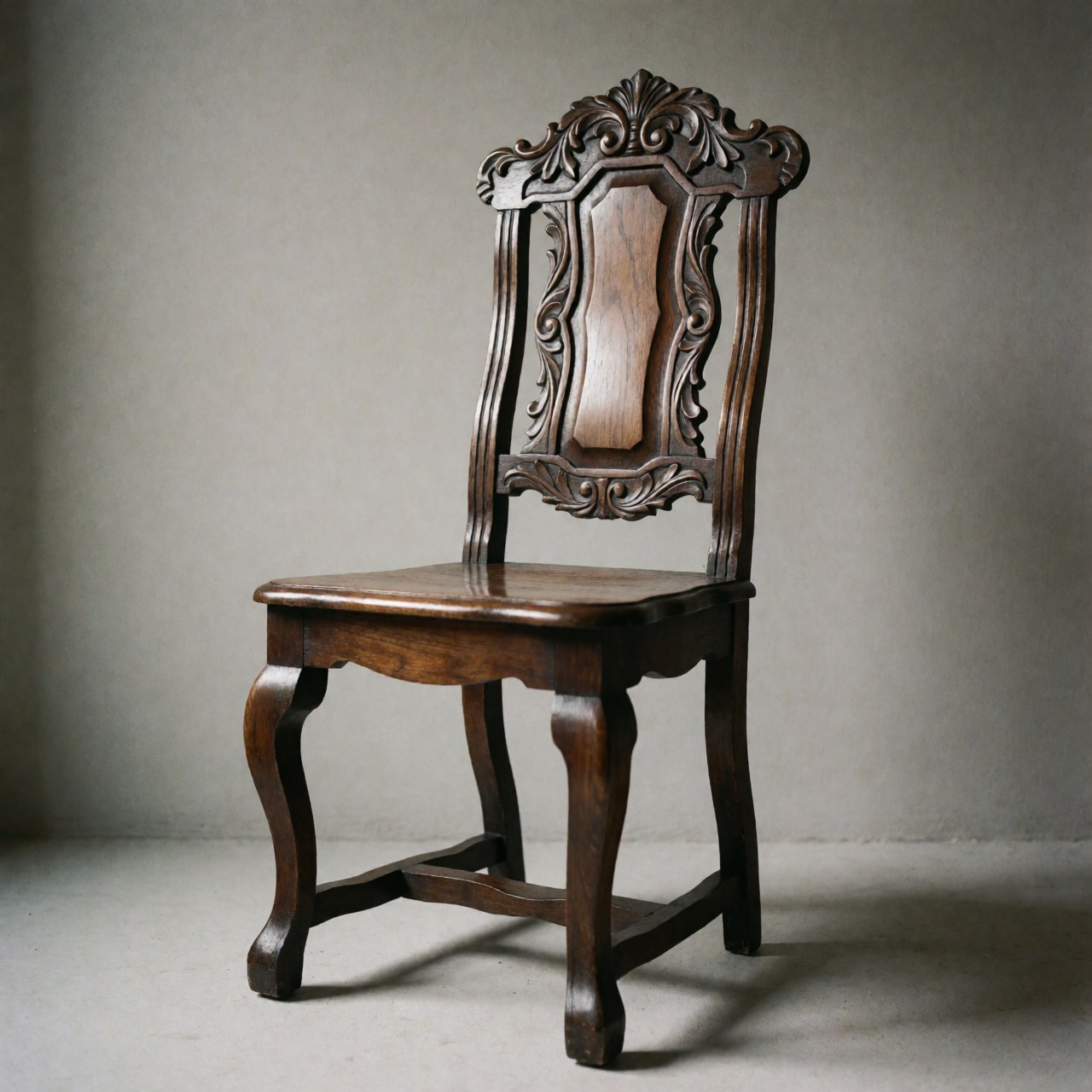 Chaise en bois restaurée avec pieds courbes et dossier sculpté sur fond gris neutre, idéale pour la réparation de meubles anciens
