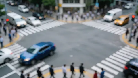 Fond de ville avec véhicules et piétons flous sur une intersection, idéal pour textes de logistique dernière millle, tons gris et bleus.