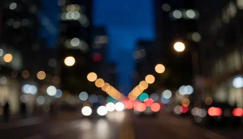 Fond flou de ville la nuit avec des lumières bleues et noires, idéal pour le transport et la logistique.