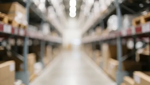 Fond d'entrepôt industriel avec des étagères métalliques et des palettes en bois, éclairage neutre, idéal pour textes commerciaux.