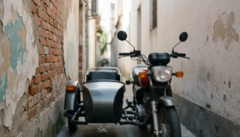 Moto-taxi stationné dans une rue étroite entre des murs de briques et une peinture écaillée, offrant un fond texturé adapté à l'ajout de texte.