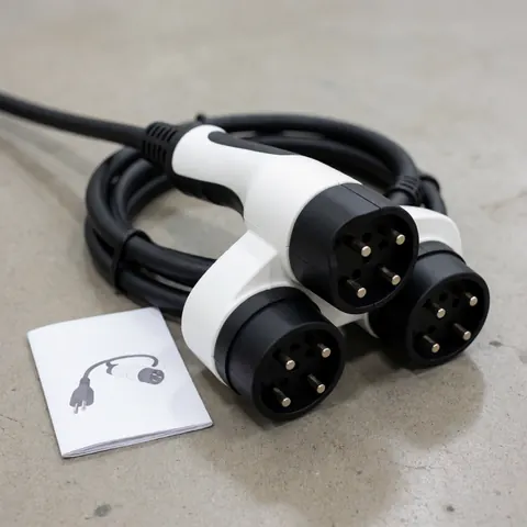 Adaptateur de charge universel pour véhicules électriques avec trois connecteurs, câble noir sur sol en béton, accompagné d'un manuel illustré.