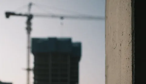 Fond de chantier avec grue et texture de béton en premier plan, idéal pour textes commerciaux.
