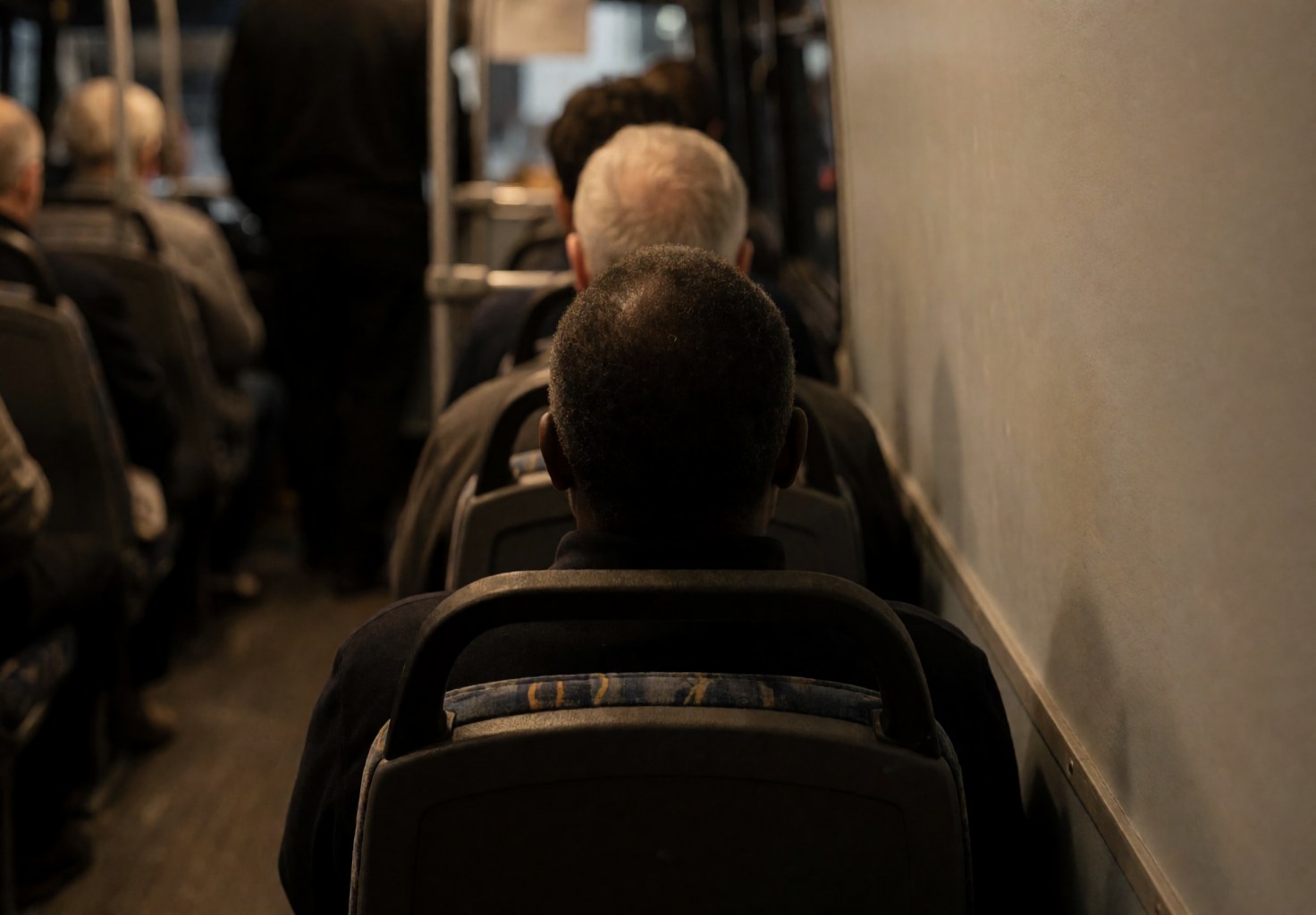 Un passager dort paisiblement sur un siège d'autocar, baigné d'une lumière chaude dans une atmosphère calme et relaxante.