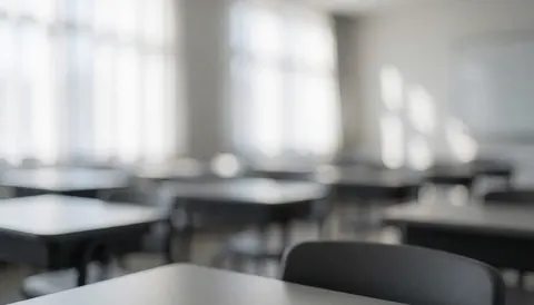 Arrière-plan d'une salle de classe moderne et vide équipée de tables et de chaises, baignée d'une douce lumière naturelle, idéal pour des textes sur les cours de robotique.