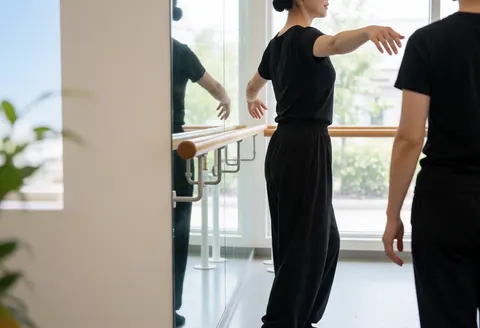Dance en studio avec barre et miroir, lumière naturelle, espace pour texte.