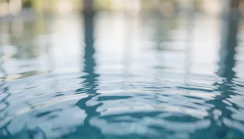 Reflets doux sur l'eau d'une piscine, idéal pour des textes, un fond serein et professionnel pour les entreprises de natation.
