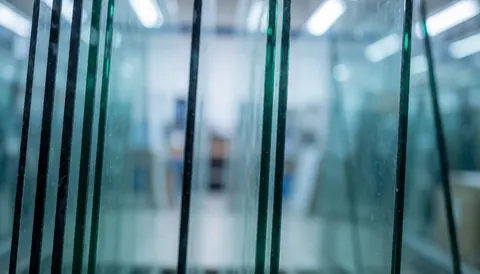 Arrière-plan professionnel d'entreposage de verre présentant des lignes verticales, éclairage bleu froid et profondeur de champ réduite, idéal pour insérer du texte commercial.