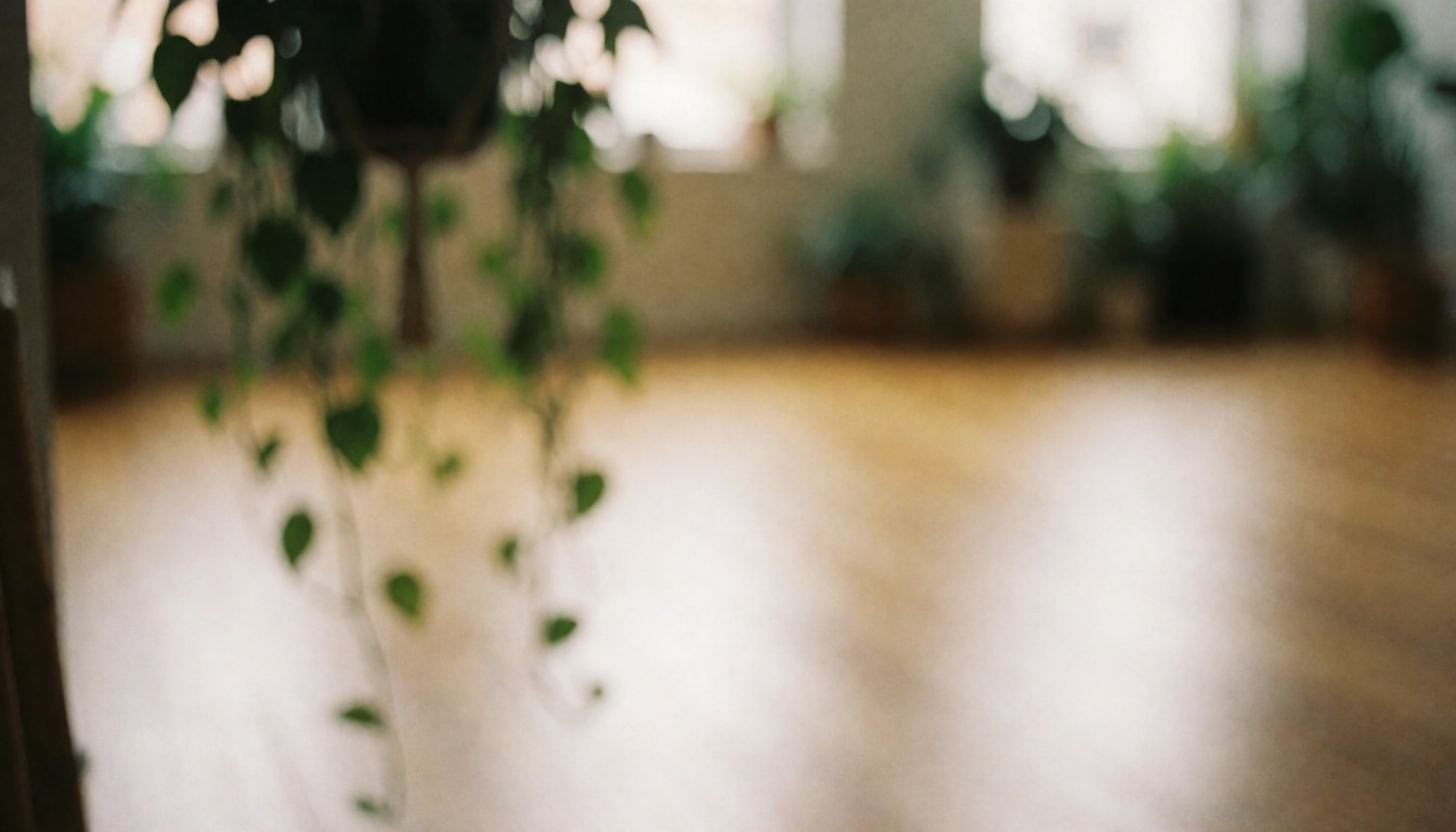 Fond de studio de yoga avec plantes suspendues et sol en bois, lumière douce et ambiance relaxante pour textes.