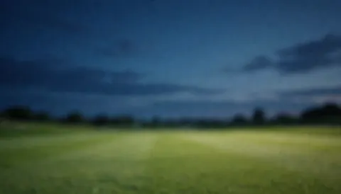 Paysage de golf au crépuscule avec un ciel bleu foncé et des nuages légers, servant de fond apaisant pour des textes ou des présentations professionnelles liées au golf.