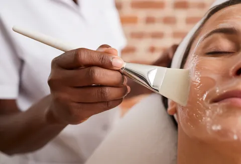 Un professionnel applique un masque hydratant sur le visage d'un client au spa.