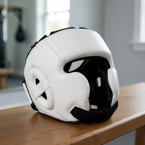 Un casque de boxe blanc avec des lanières noires posé sur un banc en bois dans un gymnastique aux murs gris et miroir.