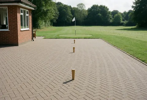 Trois tees de golf posés sur un sol en carreaux de céramique à côté d'un club de golf, idéal pour un instructeur de golf.
