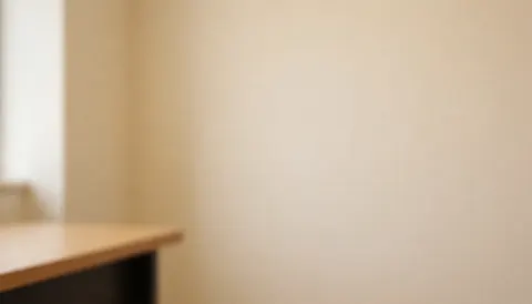 Fond serein de mur beige et bord de bureau en bois, idéal pour les textes d'une académie de langues.