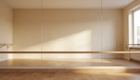 Studio de danse vide avec murs beige, sol en parquet et barre de ballet, idéal pour promouvoir des cours de danse.