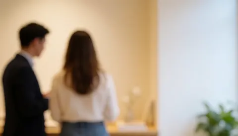 Vue arrière de deux personnes dans un intérieur aux murs clairs, laissant un espace vide à droite pour ajouter du texte.
