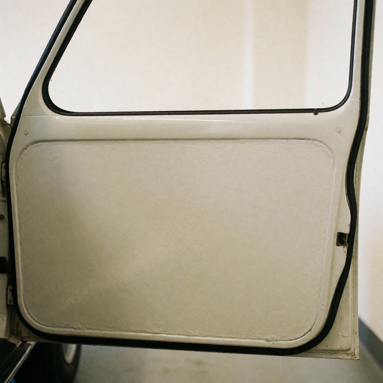 Porte de véhicule présentant une finition lisse et uniforme avec des reflets nets sur fond blanc chaud, illustrant un service professionnel de carrosserie.