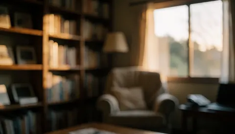 Arrière-plan flou d'un salon rural avec un fauteuil, une bibliothèque et une lumière chaude de coucher de soleil, idéal pour des textes sur l'hébergement.