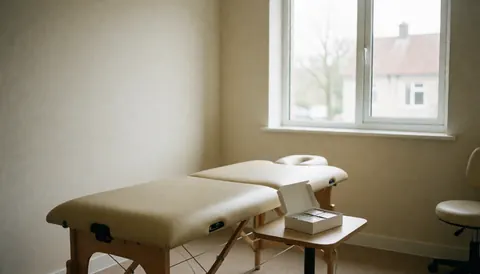 Salle propre et bien éclairée dédiée à l'ostéopathie, équipée d'une table de traitement, d'une boîte de patchs et d'une chaise de bureau.