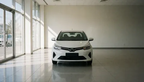 Voiture blanche exposée dans une salle de vente avec sol réfléchissant, murs neutres et lumière naturelle entrant par des fenêtres en verre, idéale pour la couverture d'un site web de vente de véhicules.