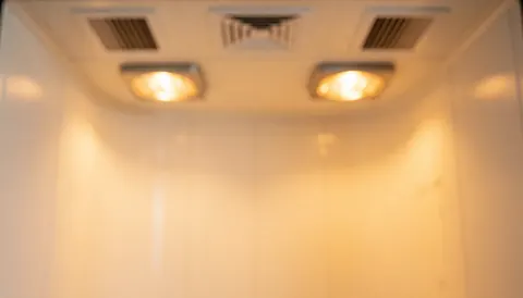 Intérieur flou d'un cabinet de séchage avec lumières infrarouges et murs blancs courbes, idéal pour les textes de peinture automobile.