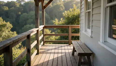 Terrasse en bois avec banc, murs gris et vue sur la forêt, idéale pour la page d'accueil d'un parc écologique.