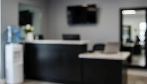 Arrière-plan de gymnase montrant un comptoir d'accueil, une bouteille d'eau et un grand miroir, espace neutre idéal pour ajouter du texte.