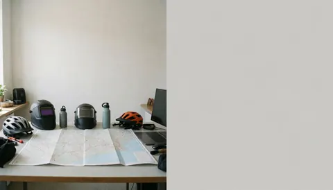 Bureau avec carte des sentiers, casques de vélo, bouteilles d'eau et ordinateur pour planifier des itinéraires de montagne.