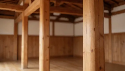 Vue des poutres en bois dans un dojo vide avec murs et sol en bois, idéal pour fond de texte dans une école d'arts martiaux