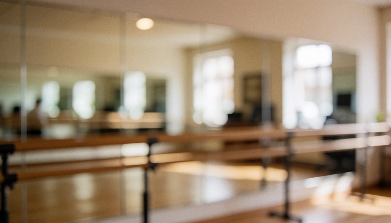 Arrière-plan flou d'un studio de danse avec barres en bois, miroirs, éclairage doux et murs beige, idéal pour ajouter du texte.