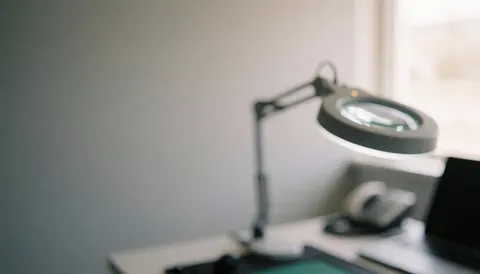 Loupe de travail sur une table de réparation avec tapis antistatique, éclairage doux et fond professionnel pour services de réparation d'ordinateurs.