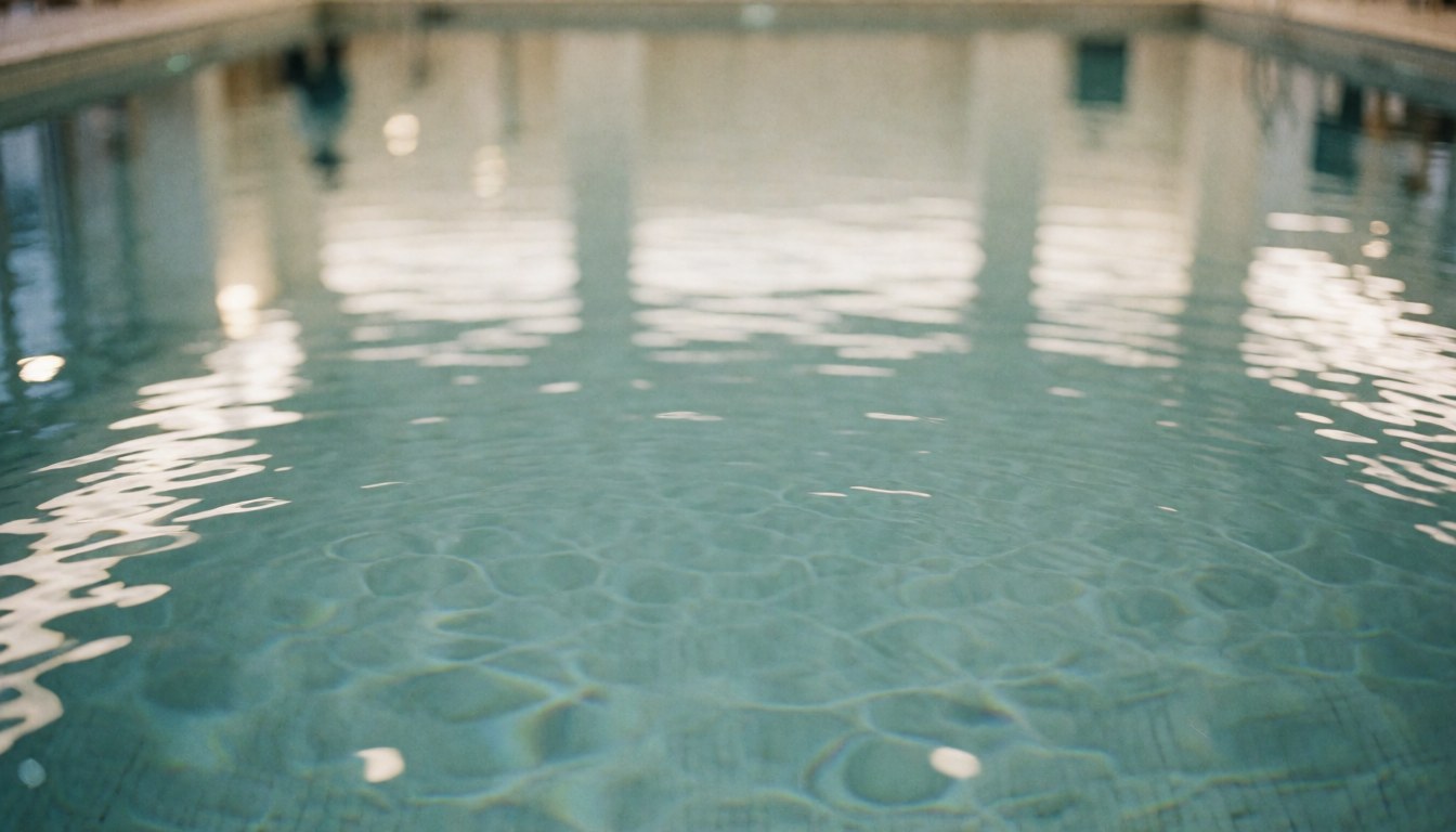 Eau claire et sereine dans une piscine intérieure avec des reflets lumineux, idéale pour un arrière-plan de texte.