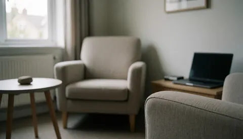 Salle de thérapie équipée de chaises confortables, d'une petite table avec une pierre et une lumière naturelle, idéale pour des textes sur l'hypnothérapie.