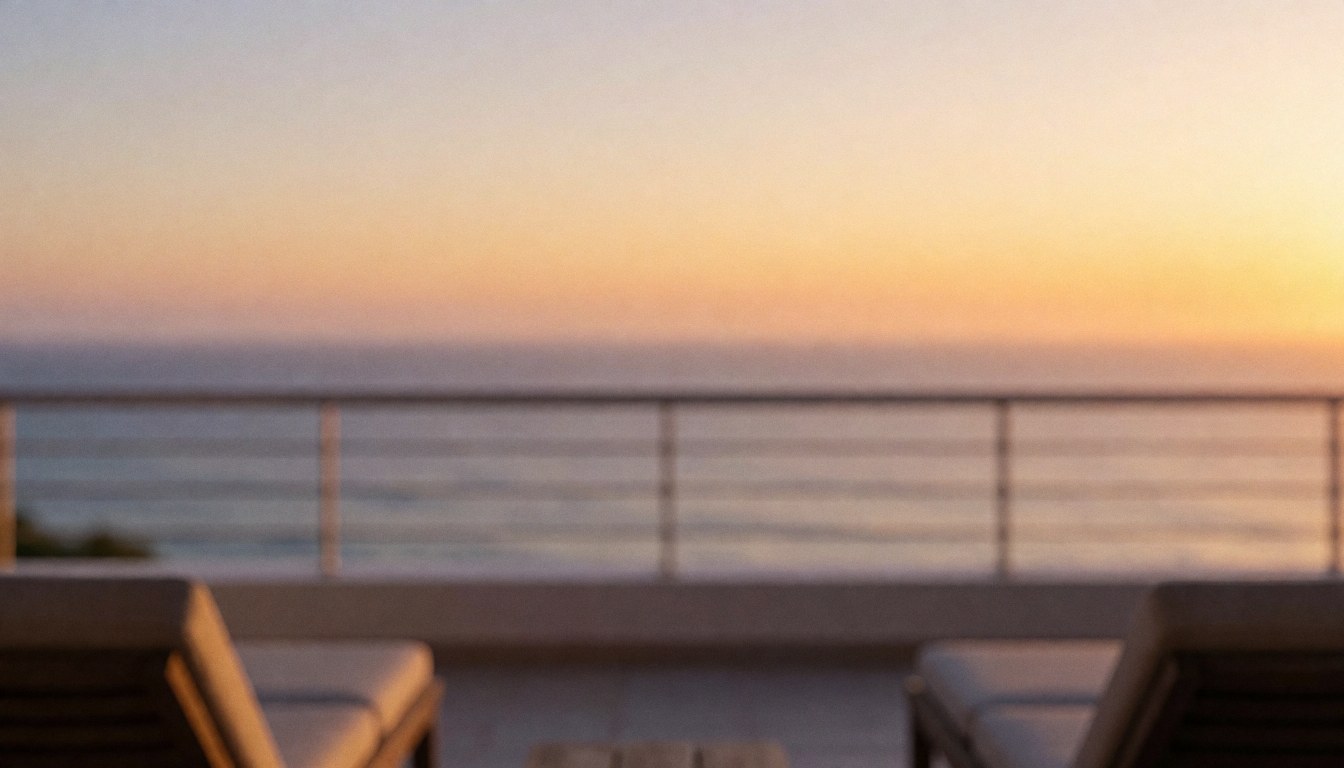 Terrasse avec chaises de plage et vue sur la mer au coucher du soleil, éclairée par une lumière dorée avec un dégradé d'orange et de violet, idéale pour ajouter du texte.